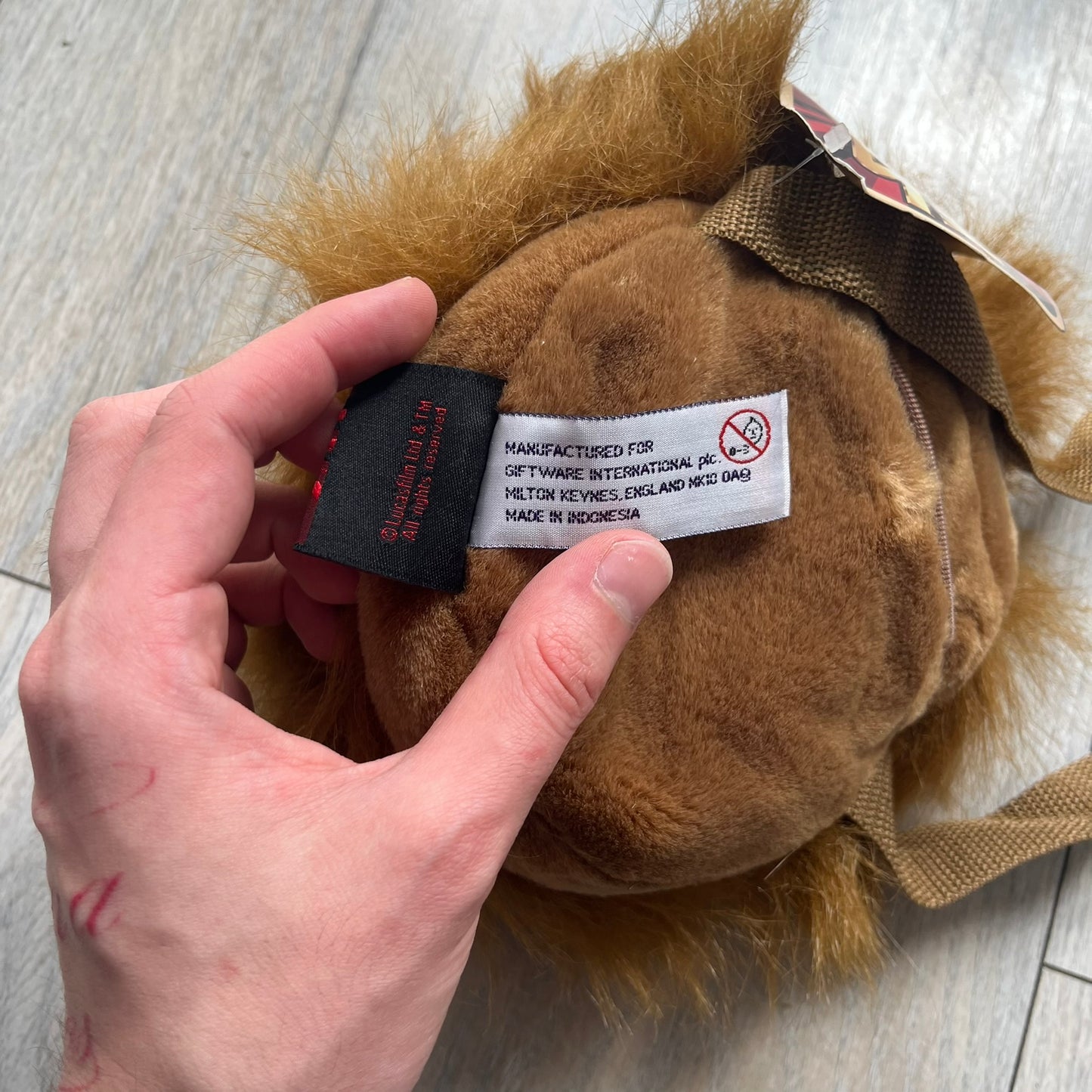 Star Wars 1990s Chewbacca Head Shoulder Bag is a novelty shoulder bag designed in the shape of Chewbacca’s head. The exterior features a furry construction with plastic eyes and a leather-like nose and mouth. It includes an adjustable shoulder strap, a single main compartment, a red Star Wars licensed tag, and the original paper tag.