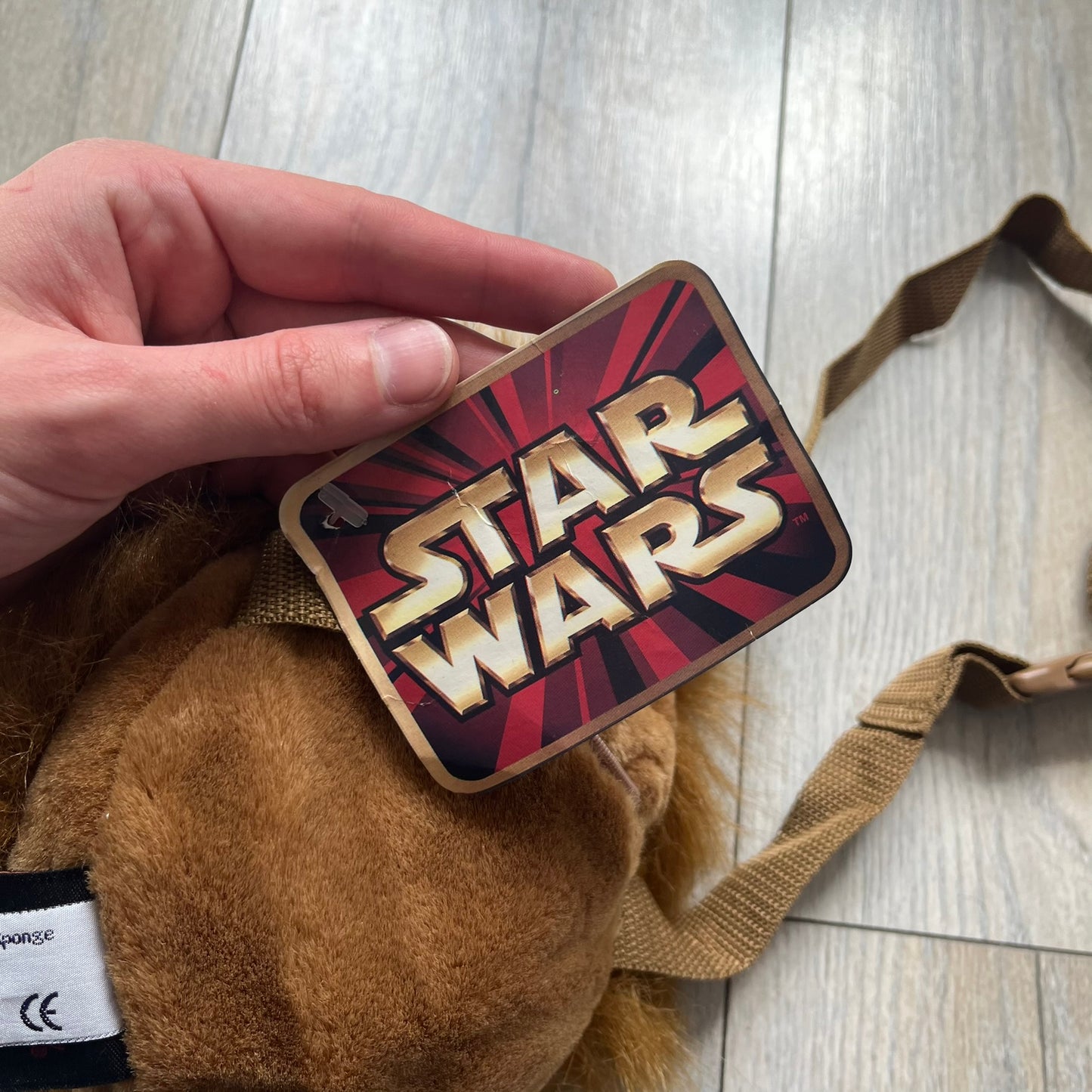 Star Wars 1990s Chewbacca Head Shoulder Bag is a novelty shoulder bag designed in the shape of Chewbacca’s head. The exterior features a furry construction with plastic eyes and a leather-like nose and mouth. It includes an adjustable shoulder strap, a single main compartment, a red Star Wars licensed tag, and the original paper tag.