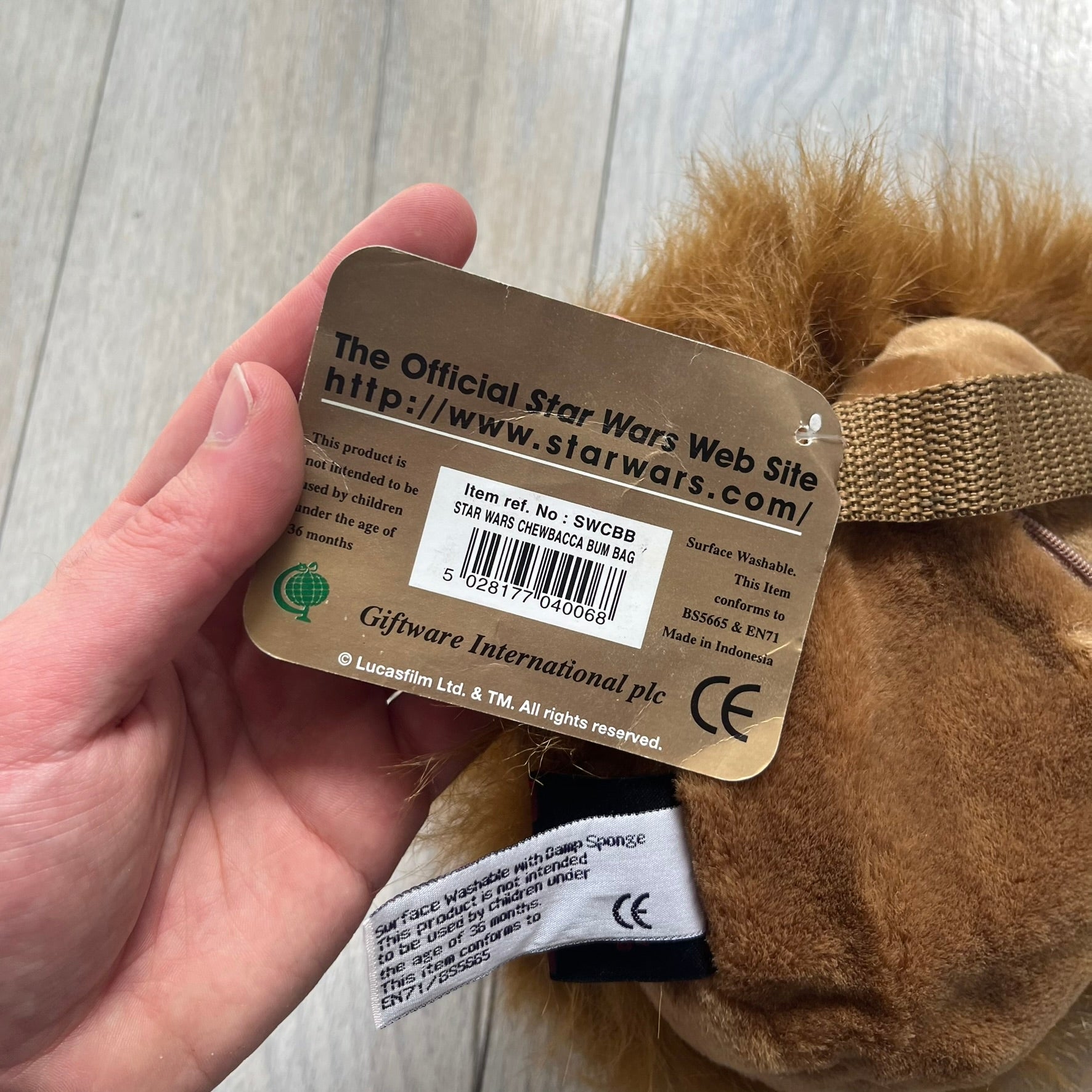 Star Wars 1990s Chewbacca Head Shoulder Bag is a novelty shoulder bag designed in the shape of Chewbacca’s head. The exterior features a furry construction with plastic eyes and a leather-like nose and mouth. It includes an adjustable shoulder strap, a single main compartment, a red Star Wars licensed tag, and the original paper tag.