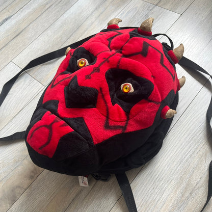 Star Wars 90's Darth Maul Head Backpack is a plush backpack shaped like Darth Maul’s head with striking red-and-black detailing and realistic plastic eyes. Features a small zip compartment on the back and adjustable straps, perfect as a collectible or standout accessory.