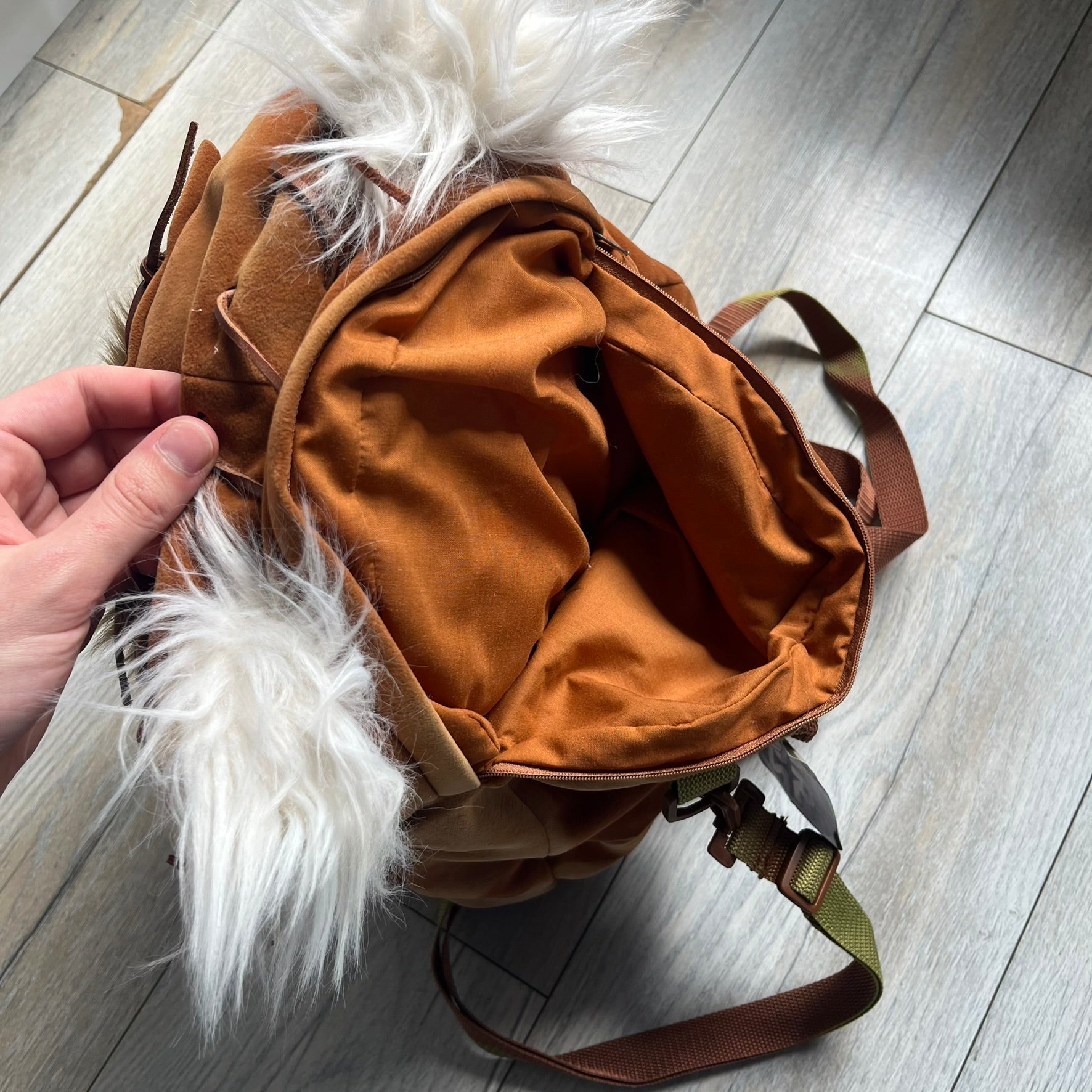 Star Wars 1990s Ewok Wicket Head Backpack is a plush backpack designed in the shape of the Ewok character Wicket W. Warrick. The bag features a brown Ewok face with a white beard and a brown hood, along with green camo-style shoulder straps. It includes a 1990s Star Wars neck tag and original paper tag.