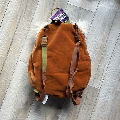 Star Wars 1990s Ewok Wicket Head Backpack is a plush backpack designed in the shape of the Ewok character Wicket W. Warrick. The bag features a brown Ewok face with a white beard and a brown hood, along with green camo-style shoulder straps. It includes a 1990s Star Wars neck tag and original paper tag.