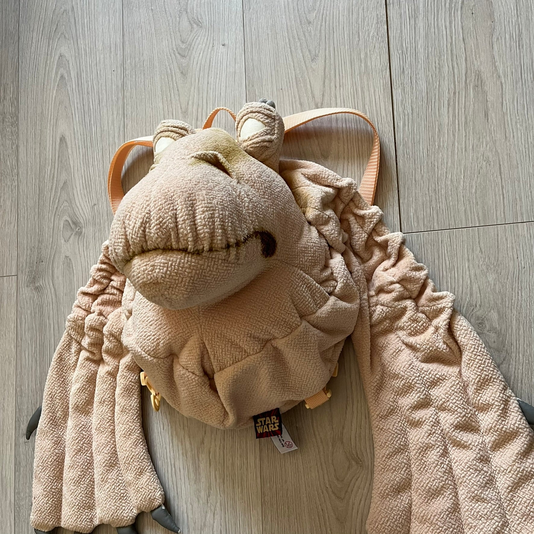 Vintage 1990s Star Wars backpack shaped like Jar Jar Binks’ head, complete with oversized ears for a playful, collectible design. This nostalgic piece captures the quirky charm of the character while offering functional storage. A rare, fun accessory for fans of classic Star Wars memorabilia.