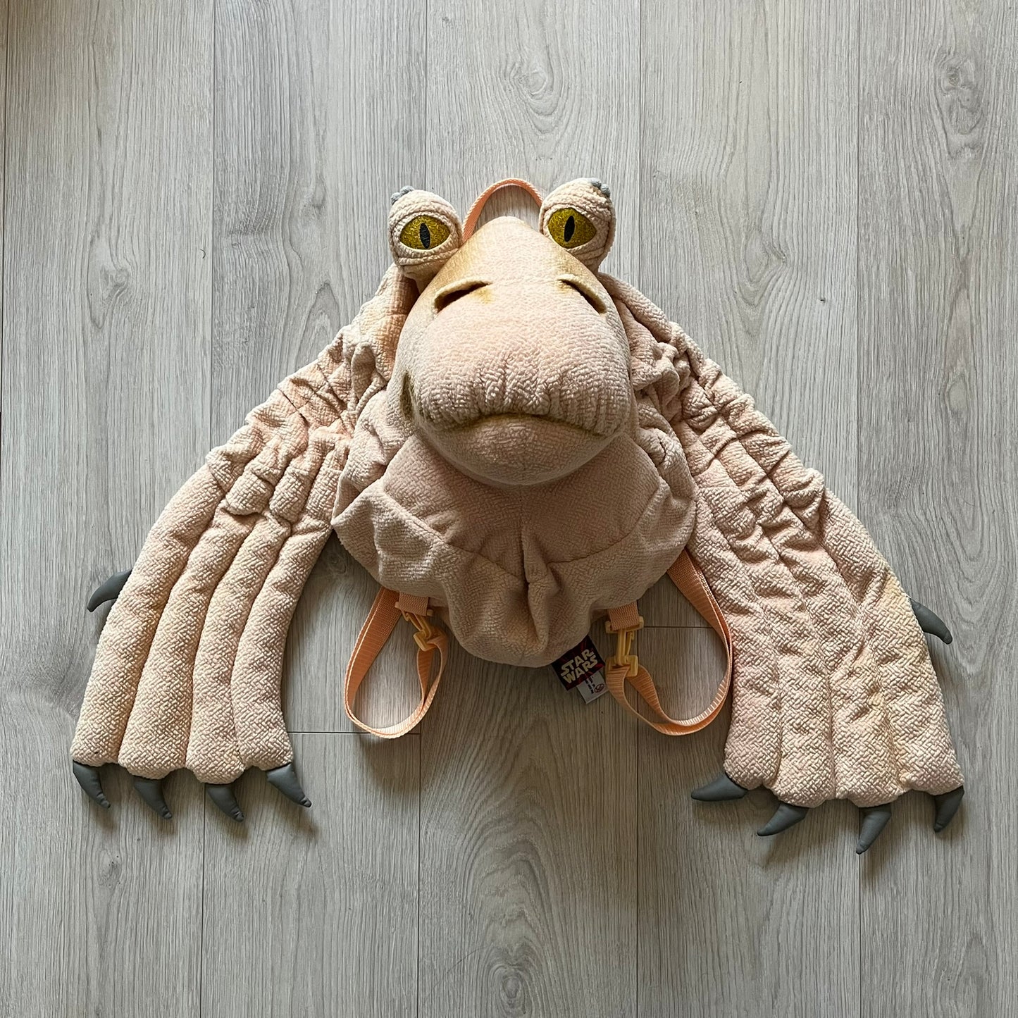 Vintage 1990s Star Wars backpack shaped like Jar Jar Binks’ head, complete with oversized ears for a playful, collectible design. This nostalgic piece captures the quirky charm of the character while offering functional storage. A rare, fun accessory for fans of classic Star Wars memorabilia.
