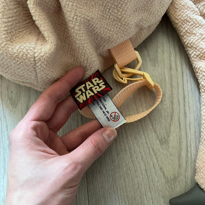 Vintage 1990s Star Wars backpack shaped like Jar Jar Binks’ head, complete with oversized ears for a playful, collectible design. This nostalgic piece captures the quirky charm of the character while offering functional storage. A rare, fun accessory for fans of classic Star Wars memorabilia.