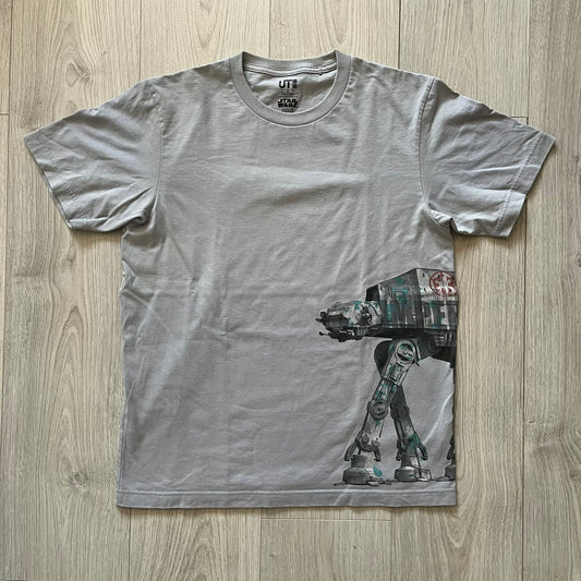 Gray t-shirt with a robot graphic on a wooden surface
