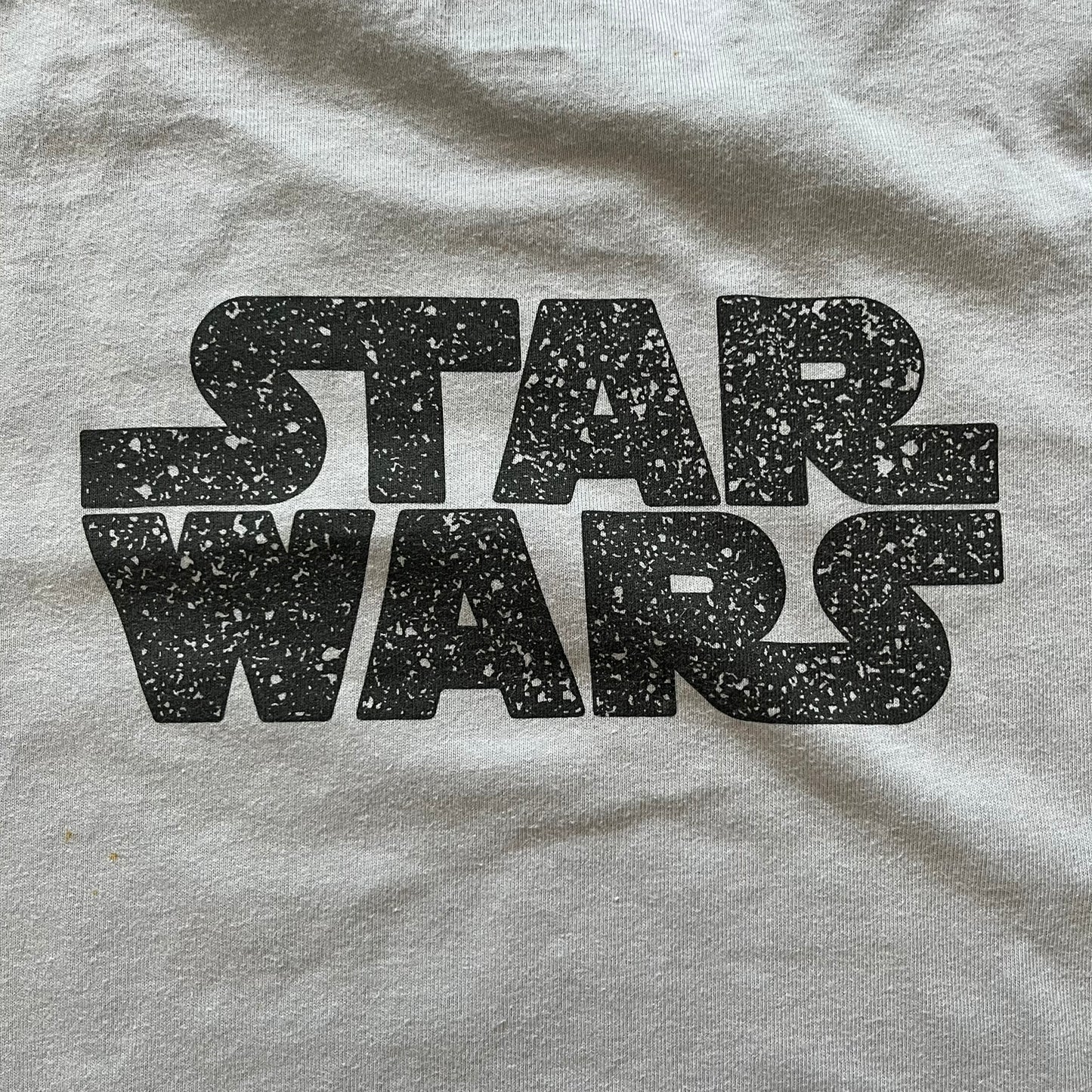 Gray t-shirt with 'STAR WARS' text in black on a textured background