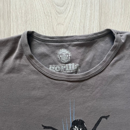 Gray Star Wh*res tee showcasing female figures in Stormtrooper and Vader masks. Logo sits prominently on the chest with witty “Available in Alderaan Places” tagline beneath. A perfect sci-fi parody tee.