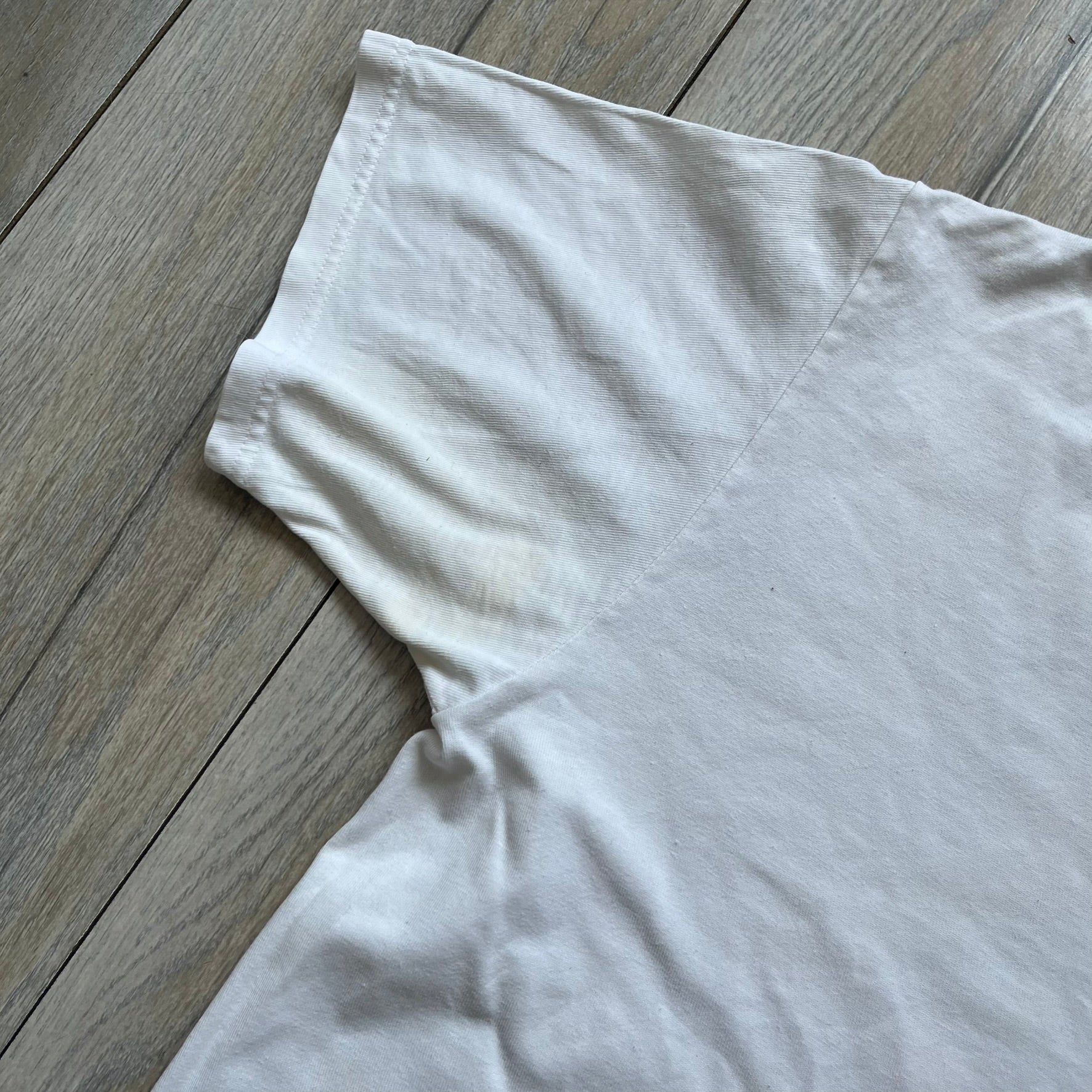 Stussy Soul 1980 White Tee is a white short-sleeve T-shirt released as part of a spring drop, made from soft cotton with a relaxed fit and ribbed collar. The front features a small Stussy logo print on the chest, while the back includes black Stussy text, a large multicolor central graphic, and “Copyright 1980” text at the bottom.