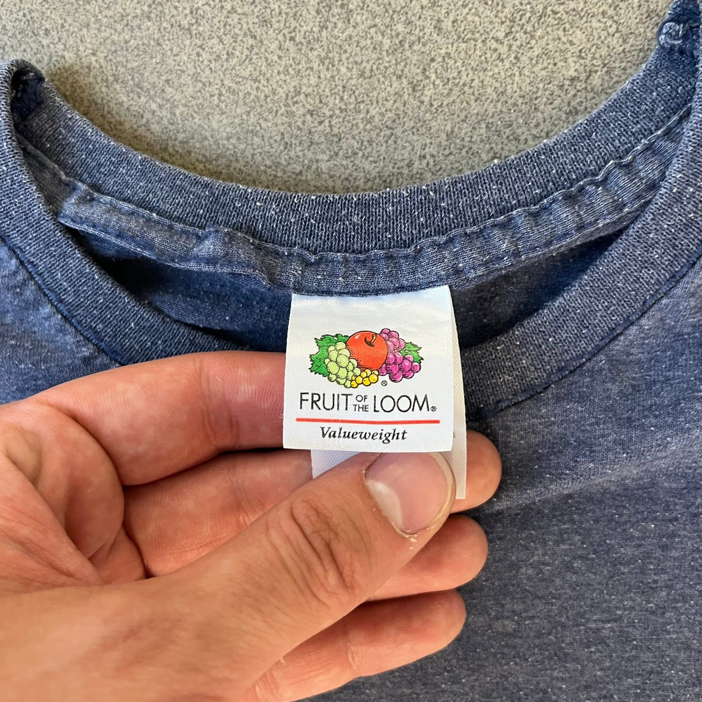 Subway Surfers 2010s Jake Tee is a grey T-shirt made on a Fruit of the Loom blank. The front features Jake, the main character from Subway Surfers, riding his skateboard, with the pursuing guard dog biting the end of the board. The design is printed in full color on the front.
