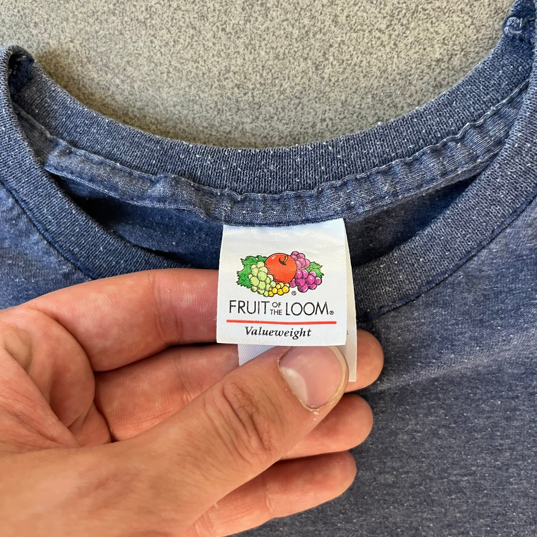 Subway Surfers 2010s Jake Tee is a grey T-shirt made on a Fruit of the Loom blank. The front features Jake, the main character from Subway Surfers, riding his skateboard, with the pursuing guard dog biting the end of the board. The design is printed in full color on the front.
