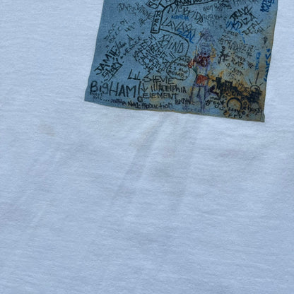 Supreme 30th Anniversary SS24 First Tee is a white T-shirt released on April 25, 2024, as part of the SS24 season. The front features a small OG Taxi Driver Supreme shirt graphic in blue with graffiti-style detailing. Below the back collar, a small gray tag displays the Supreme 30th Anniversary logo.