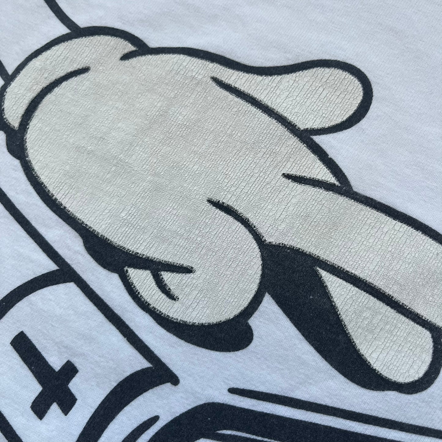 Supreme SS06 Oath White Tee is a white short-sleeve T-shirt from the Spring/Summer 2006 collection. The front features a black outline graphic of a Mickey Mouse-style hand placed on a cartoon Bible with a visible cross, with small “Supreme 2006” copyright text on the side. Super rare piece.