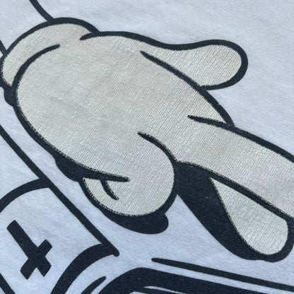 Supreme SS06 Oath White Tee is a white short-sleeve T-shirt from the Spring/Summer 2006 collection. The front features a black outline graphic of a Mickey Mouse-style hand placed on a cartoon Bible with a visible cross, with small “Supreme 2006” copyright text on the side. Super rare piece.