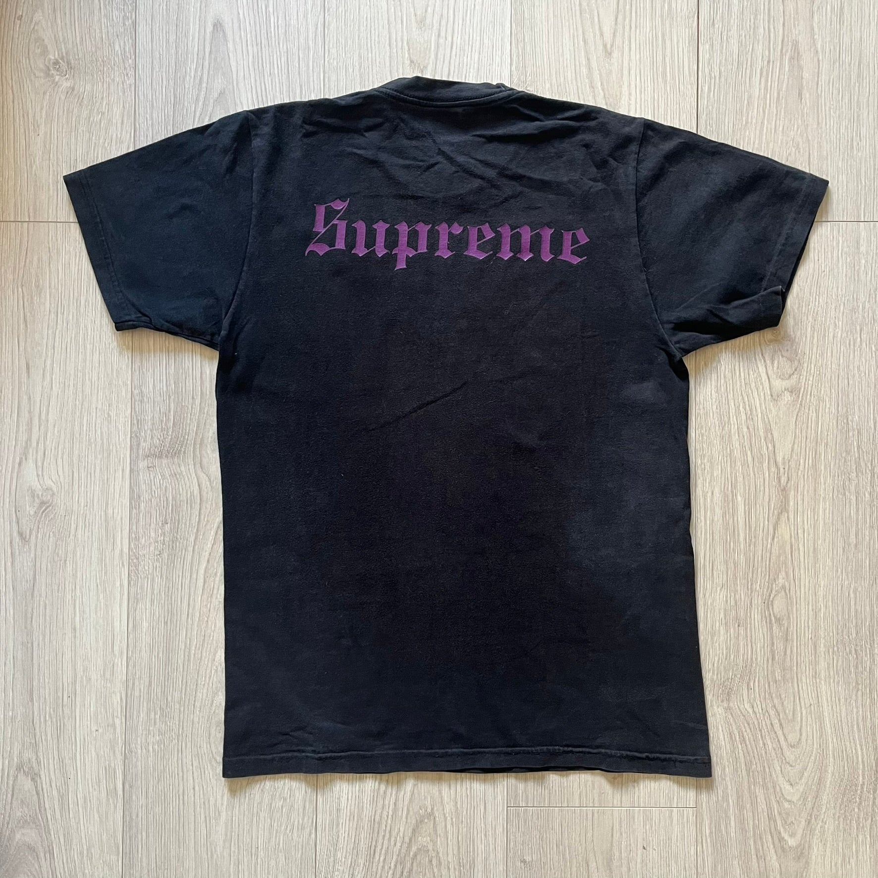From Supreme’s SS16 Black Sabbath collaboration, the Tome Tee arrives in black with striking purple graphics. The front shows the band’s Children of the Grave artwork within a book, contrasted by a gothic Supreme logo on the back. A sought-after item bridging metal iconography and Supreme’s streetwear legacy.