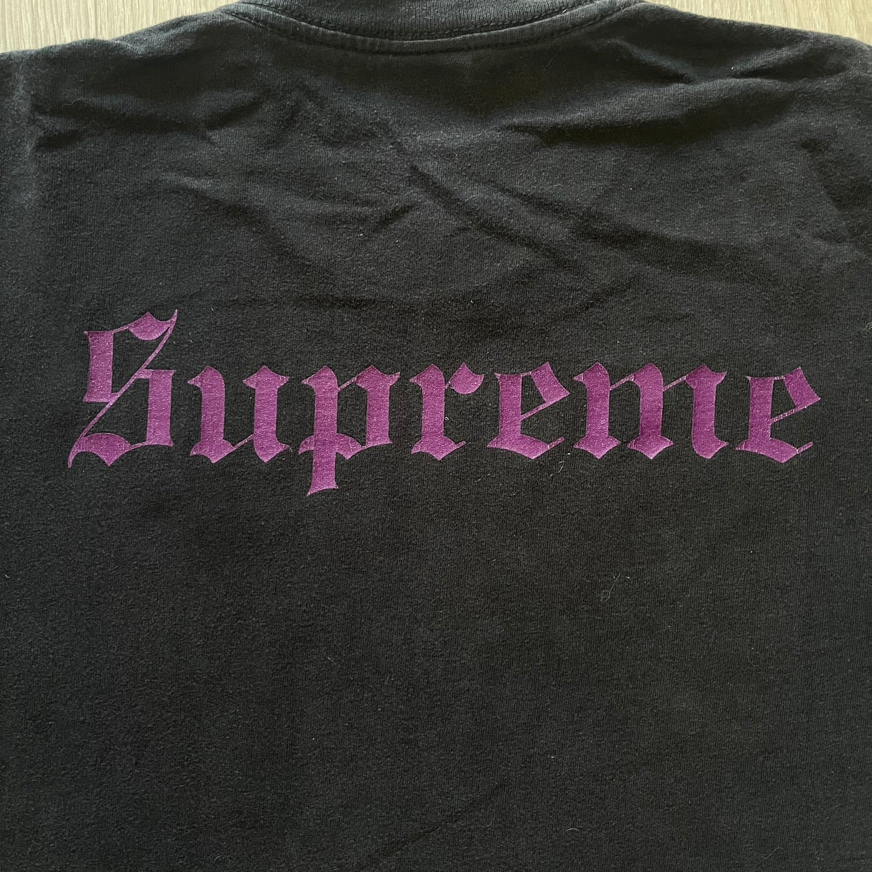 From Supreme’s SS16 Black Sabbath collaboration, the Tome Tee arrives in black with striking purple graphics. The front shows the band’s Children of the Grave artwork within a book, contrasted by a gothic Supreme logo on the back. A sought-after item bridging metal iconography and Supreme’s streetwear legacy.