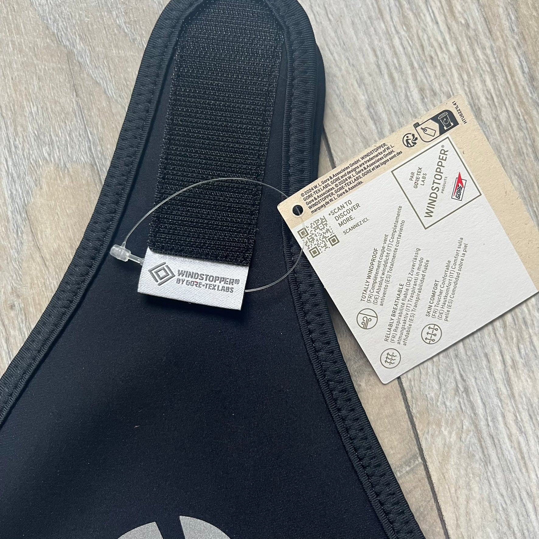 Supreme FW25 facemask produced in collaboration with GORE WINDSTOPPER® Labs, released on January 2, 2026. Constructed from water-resistant, windproof WINDSTOPPER® fabric with a fleece-bonded backing, designed for breathability and skin comfort. Features a Velcro flap closure, small front breathing perforations, nose and eye openings, a large white Supreme logo printed across the front, 3M reflective Supreme branding on the front and side, and a WINDSTOPPER® logo on the side. Finished in black.