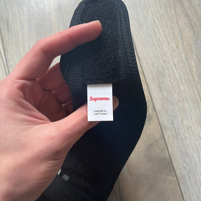 Supreme FW25 facemask produced in collaboration with GORE WINDSTOPPER® Labs, released on January 2, 2026. Constructed from water-resistant, windproof WINDSTOPPER® fabric with a fleece-bonded backing, designed for breathability and skin comfort. Features a Velcro flap closure, small front breathing perforations, nose and eye openings, a large white Supreme logo printed across the front, 3M reflective Supreme branding on the front and side, and a WINDSTOPPER® logo on the side. Finished in black.