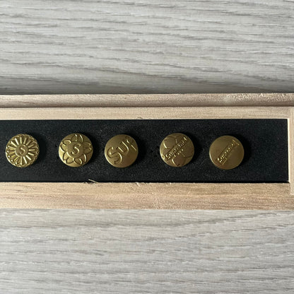 The Supreme CDW Push Pin FW24 Set, released in Week 10 (October 2024), offers eight brass-made pins with detailed debossed graphics including the classic Box Logo and “Fuck Em!” motif. Produced in Japan, this set turns simple desk essentials into collectible Supreme artifacts.