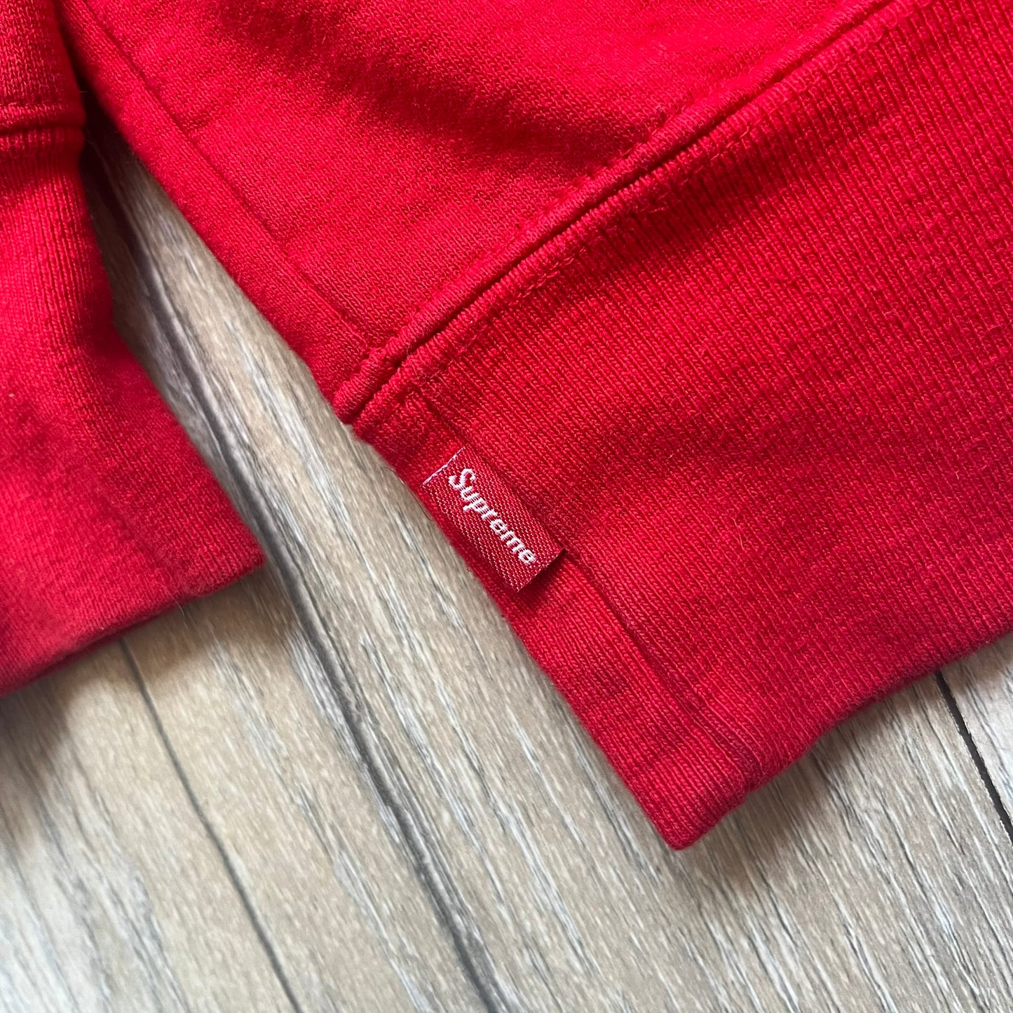 Supreme Catwoman FW23 Hooded Sweatshirt is a red pullover hoodie released on October 19, 2023. It features a drawstring hood, kangaroo pocket, and ribbed cuffs and hem. A small Supreme box logo is placed on the left chest in black.&nbsp;The back features a large Catwoman mask graphic combined with Supreme branding across the width of the design in black and green.