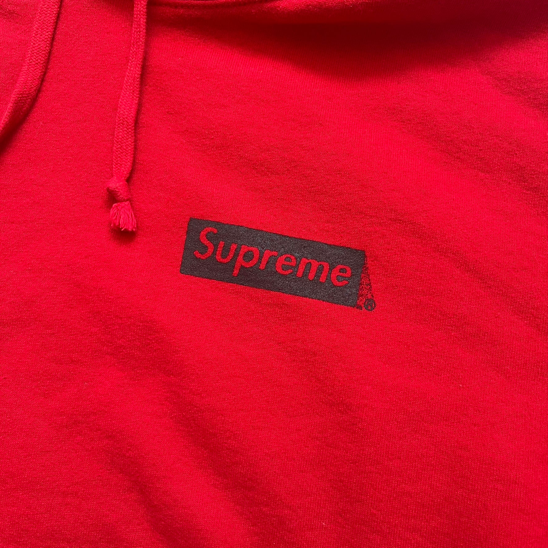 Supreme Catwoman FW23 Hooded Sweatshirt is a red pullover hoodie released on October 19, 2023. It features a drawstring hood, kangaroo pocket, and ribbed cuffs and hem. A small Supreme box logo is placed on the left chest in black.&nbsp;The back features a large Catwoman mask graphic combined with Supreme branding across the width of the design in black and green.
