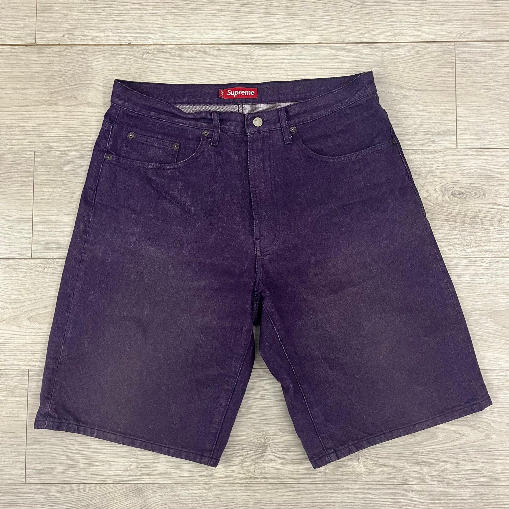 Supreme Denim Purple SS25 Baggy Shorts crafted from 13 oz. all-cotton denim in a purple hue. Features a relaxed baggy fit, classic five-pocket styling, zip fly, copper oxide rivets, and embroidered Supreme New York logo on the back pocket. Durable, stylish, and perfect for everyday streetwear.