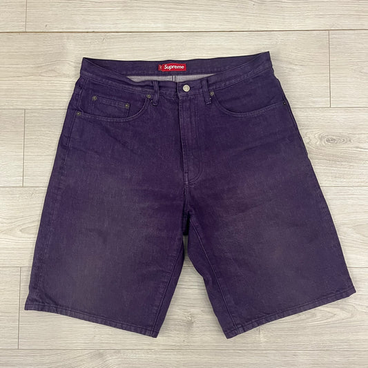 Supreme Denim Purple SS25 Baggy Shorts crafted from 13 oz. all-cotton denim in a purple hue. Features a relaxed baggy fit, classic five-pocket styling, zip fly, copper oxide rivets, and embroidered Supreme New York logo on the back pocket. Durable, stylish, and perfect for everyday streetwear.