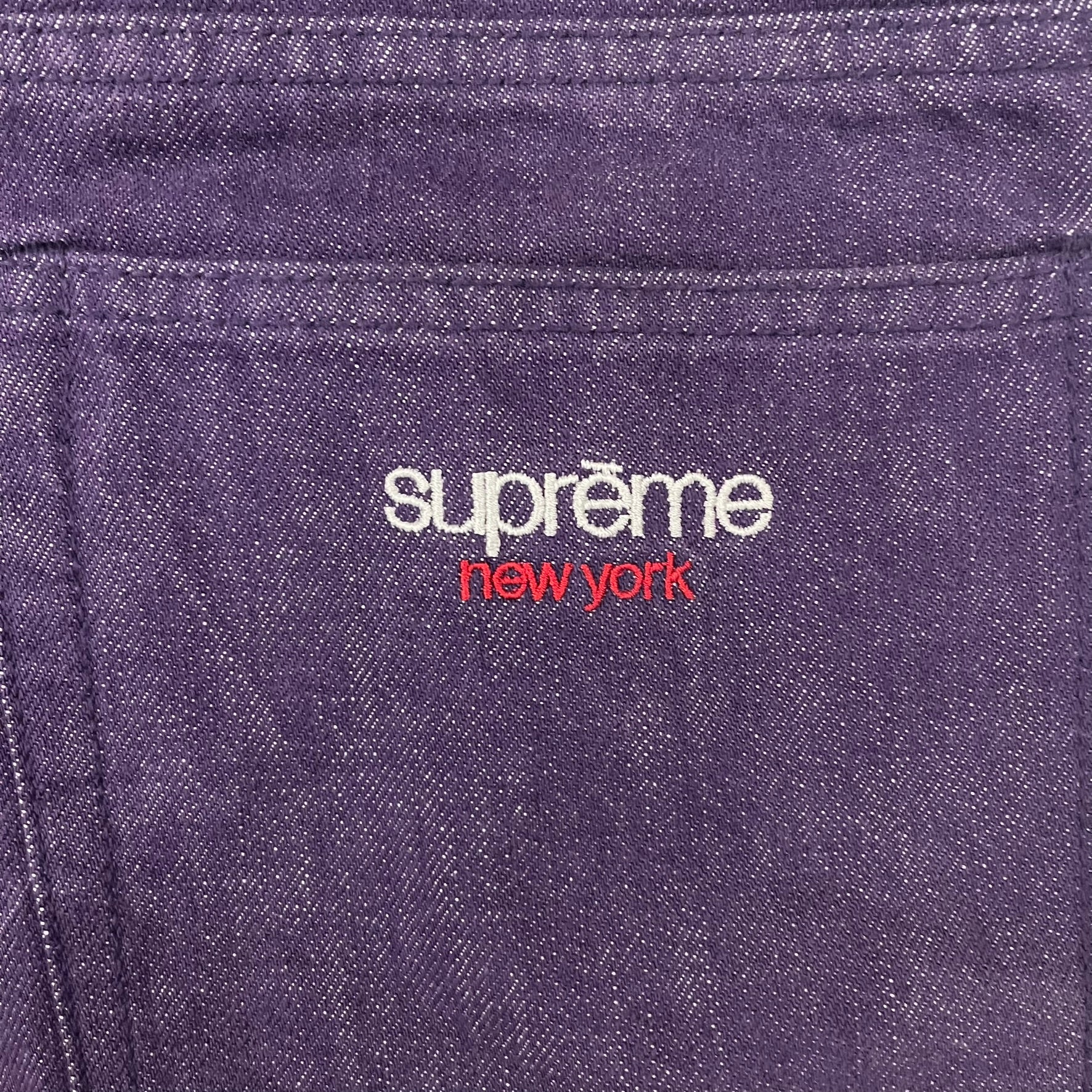 Supreme Denim Purple SS25 Baggy Shorts crafted from 13 oz. all-cotton denim in a purple hue. Features a relaxed baggy fit, classic five-pocket styling, zip fly, copper oxide rivets, and embroidered Supreme New York logo on the back pocket. Durable, stylish, and perfect for everyday streetwear.