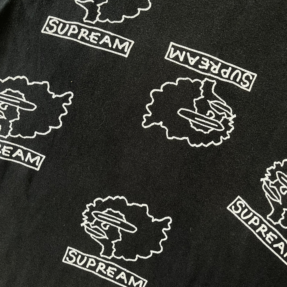 Supreme FW17 Gonz Heads Tee is a black T-shirt from the Fall/Winter 2017 collection created in collaboration with Mark Gonzales (The Gonz). The tee features repeated white Gonz head graphics printed across both the front and back in different orientations. The shirt is made in the USA.