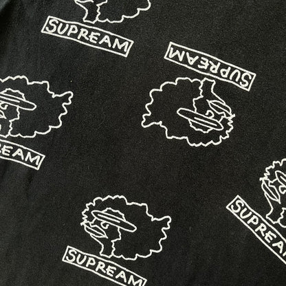 Supreme FW17 Gonz Heads Tee is a black T-shirt from the Fall/Winter 2017 collection created in collaboration with Mark Gonzales (The Gonz). The tee features repeated white Gonz head graphics printed across both the front and back in different orientations. The shirt is made in the USA.