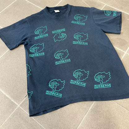 Supreme FW17 Gonz Heads Tee is a navy T-shirt from the Fall/Winter 2017 collection created in collaboration with Mark Gonzales (The Gonz). The tee features repeated green Gonz head graphics printed across both the front and back in different orientations. The shirt is made in the USA.
