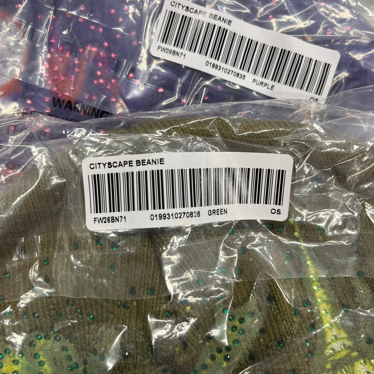 Supreme FW26 Cityscape Art Dealer Green&nbsp; Beanie is a green acrylic beanie with original artwork by Art Dealer, featuring a lime and dark green night city graphic with a moon and small stars across the sky on both sides. An old English-style Supreme logo sits on the front, and rhinestone appliqués in different sizes decorate the front and back. The print is stretchy, so any cracking effect that appears is just the print stretching with wear.