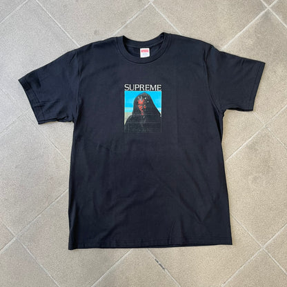 Supreme FW26 Darth Maul Sith Black Tee features a black 100% cotton T-shirt with a photo graphic of Darth Maul on a blue background. A white Supreme logo is printed above the graphic. Features a licensed Star Wars neck tag and is made in Honduras.

