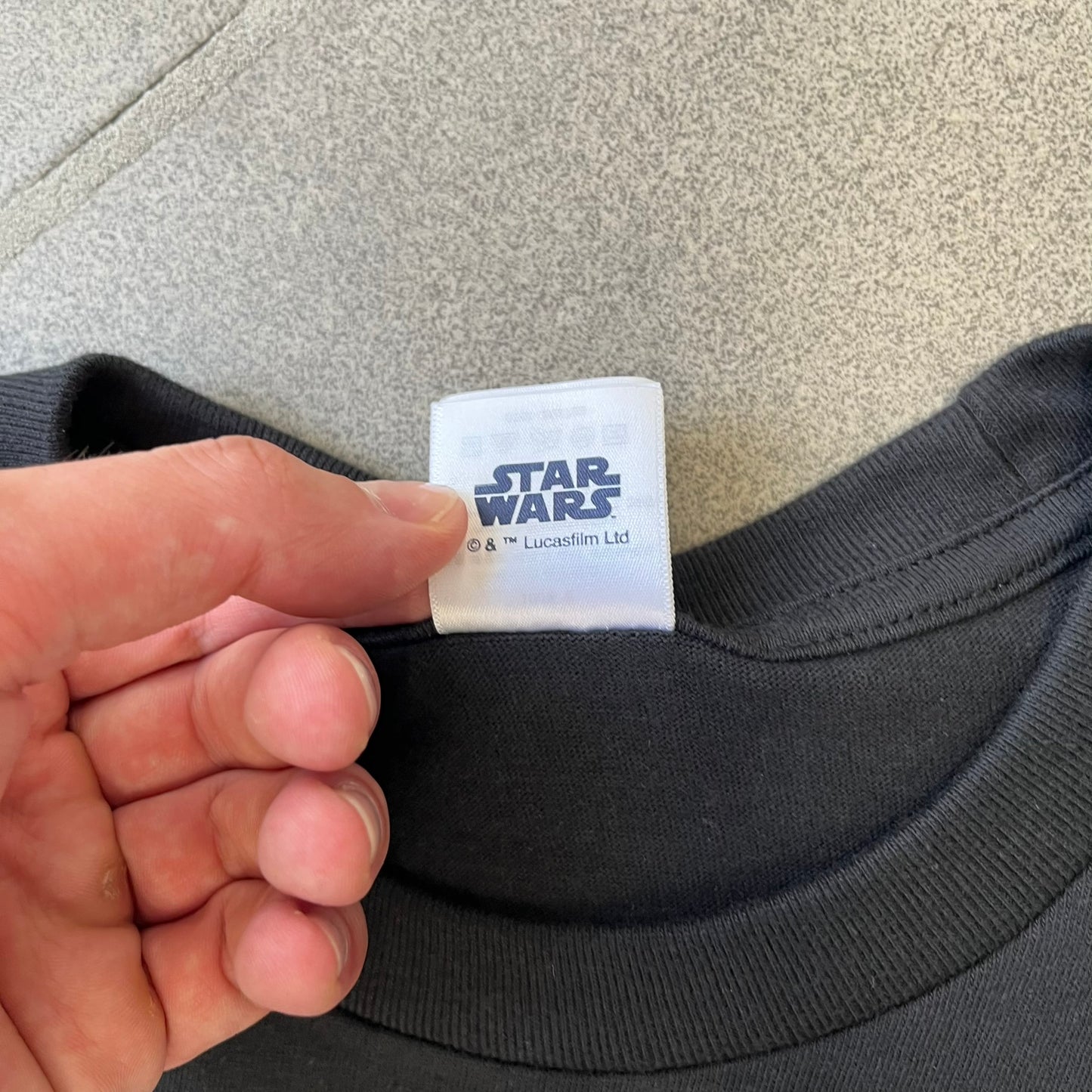Supreme FW26 Darth Maul Sith Black Tee features a black 100% cotton T-shirt with a photo graphic of Darth Maul on a blue background. A white Supreme logo is printed above the graphic. Features a licensed Star Wars neck tag and is made in Honduras.
