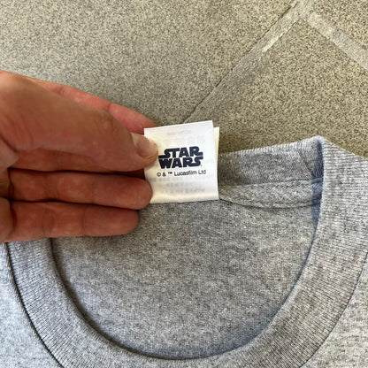 Supreme FW26 Darth Maul Sith Gray Tee features a black 90% cotton and 10% polyester T-shirt with a photo graphic of Darth Maul on a blue background. A white Supreme logo is printed above the graphic. Features a licensed Star Wars neck tag and is made in Honduras.
