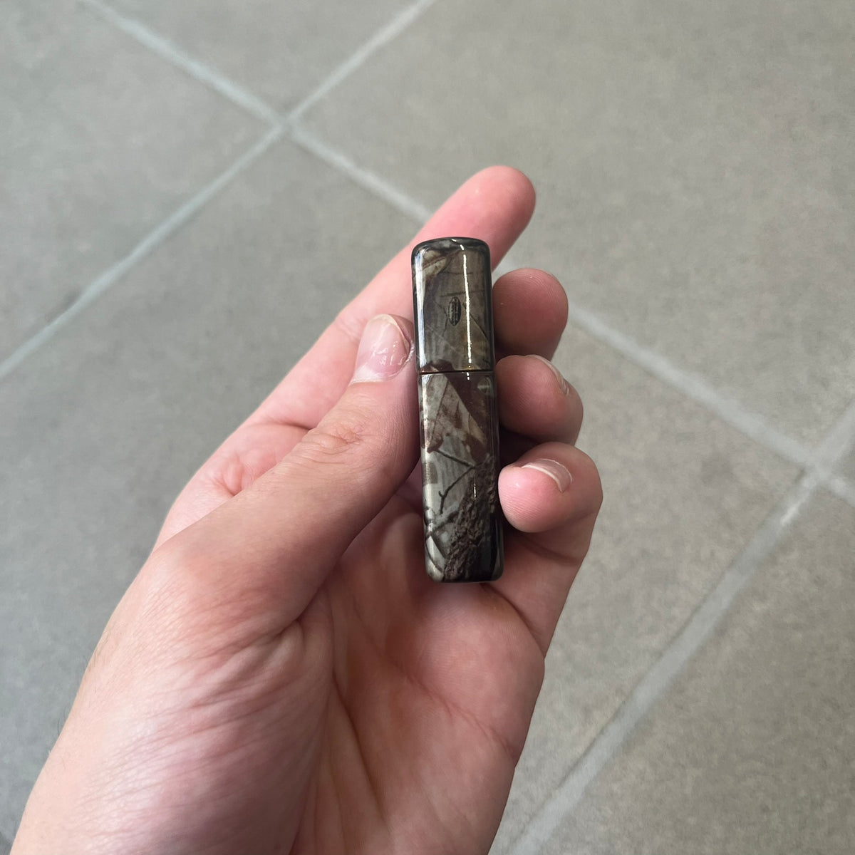 Supreme FW26 RealTree Camo Logo Zippo Lighter is an original Zippo featuring a full RealTree camo graphic with the Supreme box logo on the front. It comes with the original Zippo box and has never been filled.