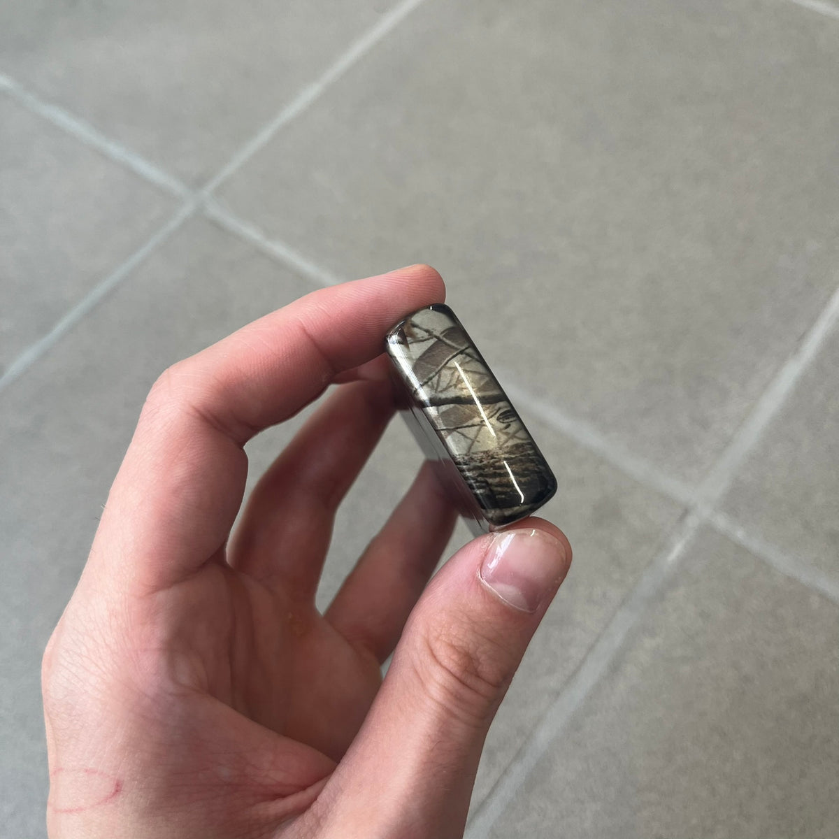Supreme FW26 RealTree Camo Logo Zippo Lighter is an original Zippo featuring a full RealTree camo graphic with the Supreme box logo on the front. It comes with the original Zippo box and has never been filled.