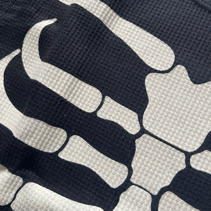 Supreme Hanes Bones Thermal Crew from FW25, crafted from 100% cotton in black with white bone graphics. Features a ribcage-inspired skeleton print on the front, matching arm bone designs on the sleeves, and a small Supreme logo near the hem. Released on October 23, 2025.