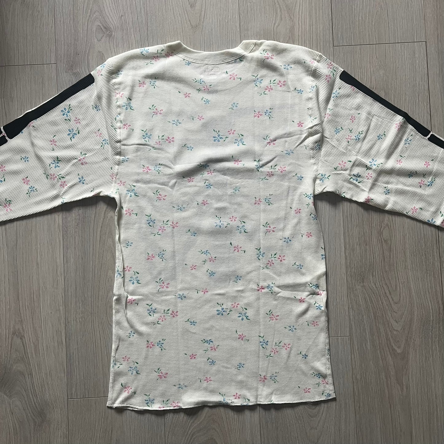 Supreme Hanes Bones Thermal Crew from FW25, crafted from 100% cotton in natural/white with black bone graphics and small floral all over print. Features a ribcage-inspired skeleton print on the front, matching arm bone designs on the sleeves, and a small Supreme logo near the hem. Released on October 23, 2025.