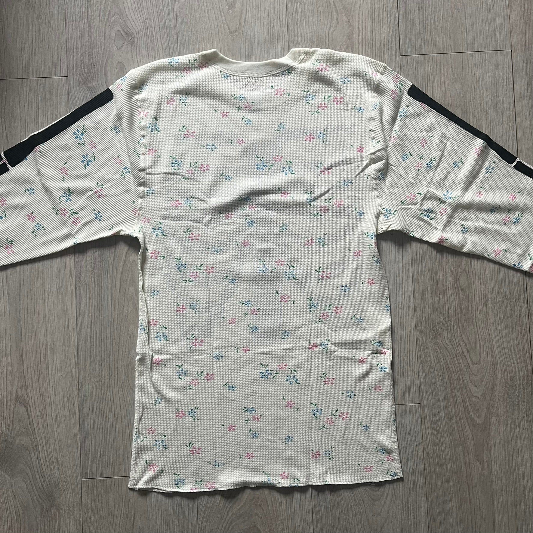 Supreme Hanes Bones Thermal Crew from FW25, crafted from 100% cotton in natural/white with black bone graphics and small floral all over print. Features a ribcage-inspired skeleton print on the front, matching arm bone designs on the sleeves, and a small Supreme logo near the hem. Released on October 23, 2025.