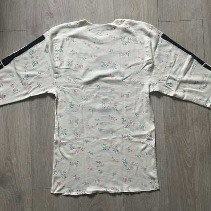 Supreme Hanes Bones Thermal Crew from FW25, crafted from 100% cotton in natural/white with black bone graphics and small floral all over print. Features a ribcage-inspired skeleton print on the front, matching arm bone designs on the sleeves, and a small Supreme logo near the hem. Released on October 23, 2025.