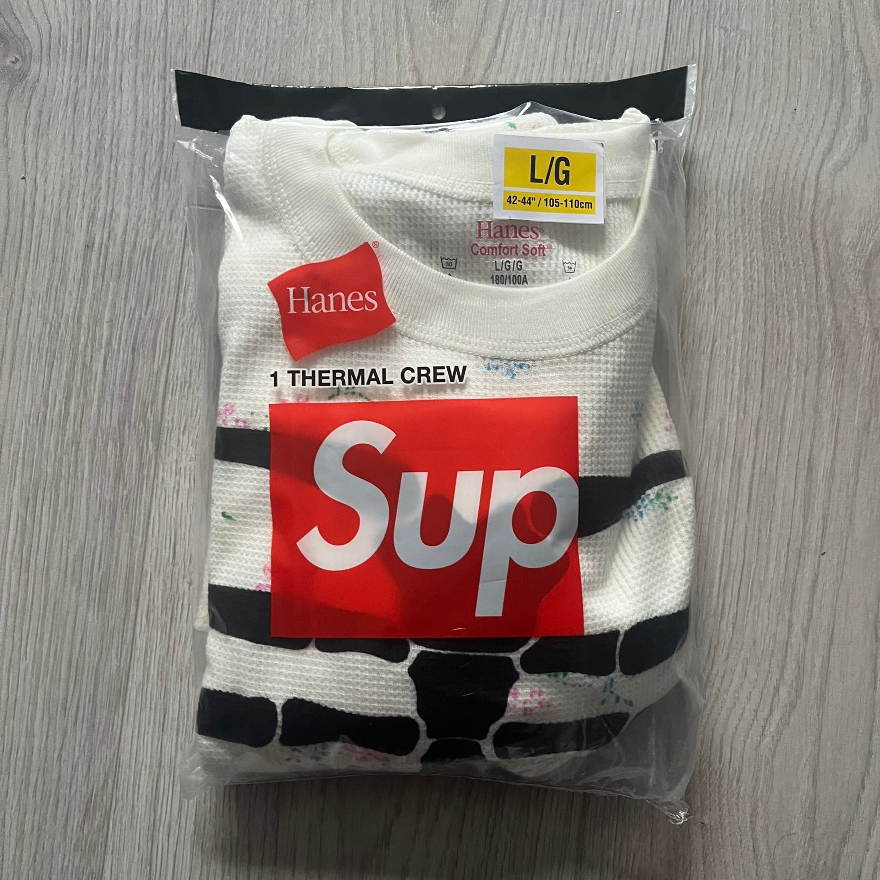 Supreme Hanes Bones Thermal Crew from FW25, crafted from 100% cotton in natural/white with black bone graphics and small floral all over print. Features a ribcage-inspired skeleton print on the front, matching arm bone designs on the sleeves, and a small Supreme logo near the hem. Released on October 23, 2025.