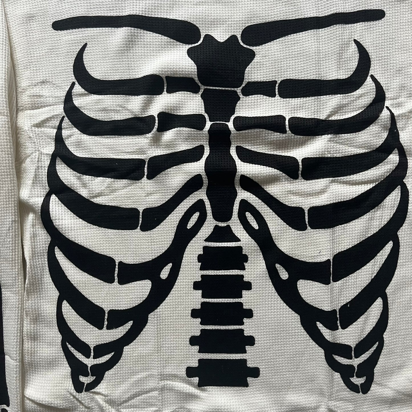 Supreme Hanes Bones Thermal Crew from FW25, crafted from 100% cotton in natural/white with black bone graphics. Features a ribcage-inspired skeleton print on the front, matching arm bone designs on the sleeves, and a small Supreme logo near the hem. Released on October 23, 2025.