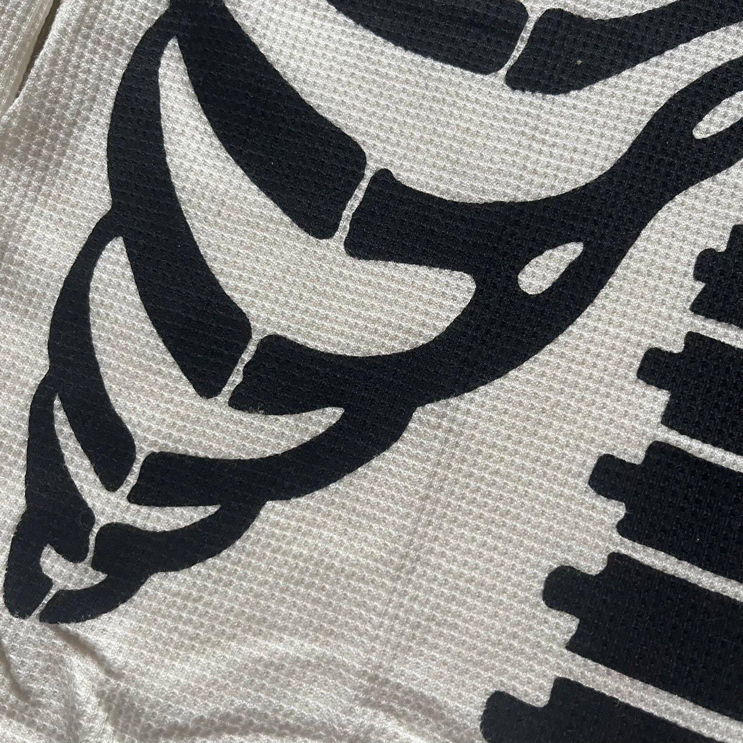 Supreme Hanes Bones Thermal Crew from FW25, crafted from 100% cotton in natural/white with black bone graphics. Features a ribcage-inspired skeleton print on the front, matching arm bone designs on the sleeves, and a small Supreme logo near the hem. Released on October 23, 2025.