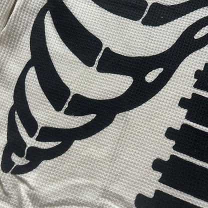 Supreme Hanes Bones Thermal Crew from FW25, crafted from 100% cotton in natural/white with black bone graphics. Features a ribcage-inspired skeleton print on the front, matching arm bone designs on the sleeves, and a small Supreme logo near the hem. Released on October 23, 2025.