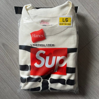 Supreme Hanes Bones Thermal Crew from FW25, crafted from 100% cotton in natural/white with black bone graphics. Features a ribcage-inspired skeleton print on the front, matching arm bone designs on the sleeves, and a small Supreme logo near the hem. Released on October 23, 2025.