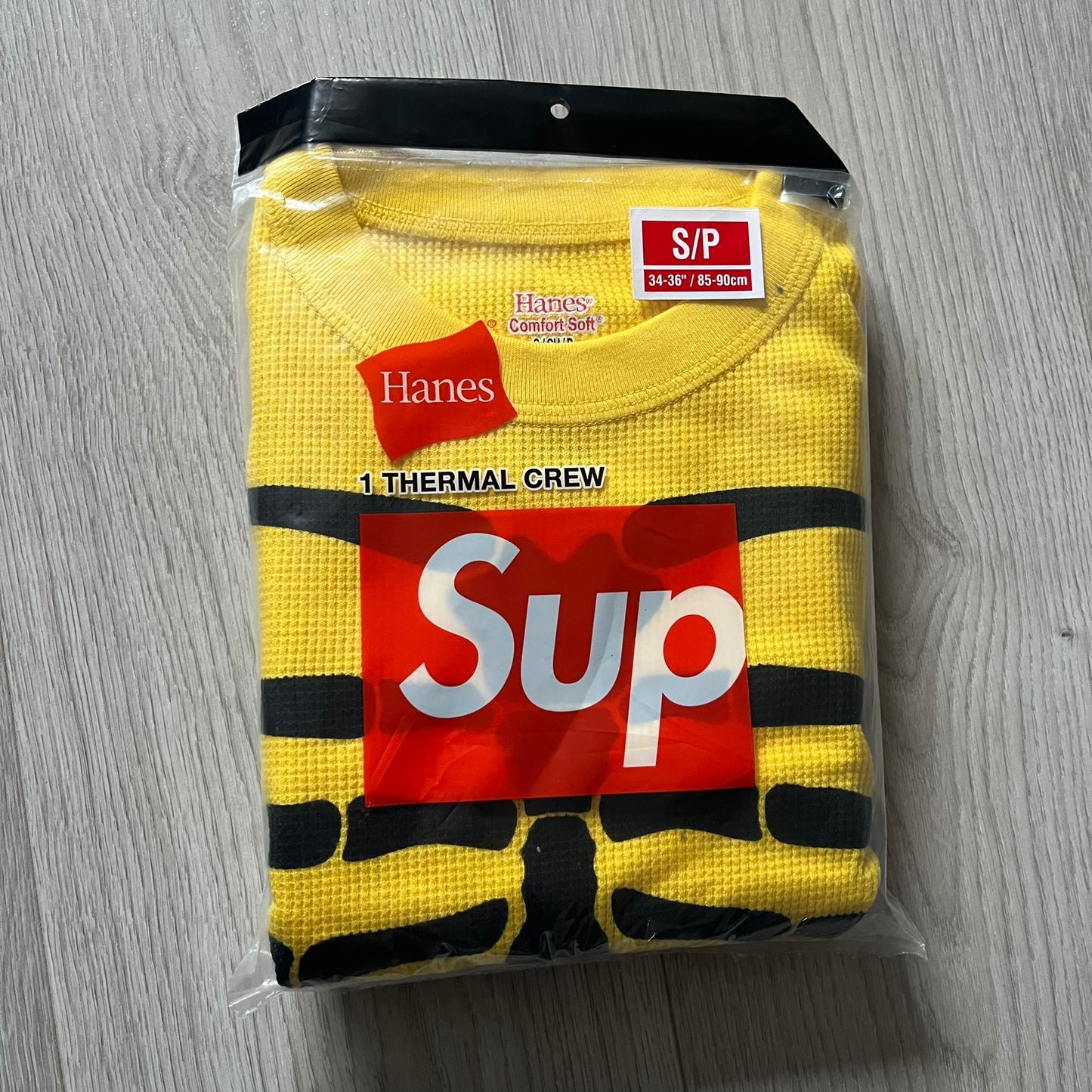 Supreme Hanes Bones Thermal Crew from FW25, crafted from 100% cotton in yellow with black bone graphics. Features a ribcage-inspired skeleton print on the front, matching arm bone designs on the sleeves, and a small Supreme logo near the hem. Released on October 23, 2025.