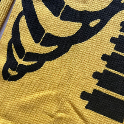 Supreme Hanes Bones Thermal Crew from FW25, crafted from 100% cotton in yellow with black bone graphics. Features a ribcage-inspired skeleton print on the front, matching arm bone designs on the sleeves, and a small Supreme logo near the hem. Released on October 23, 2025.