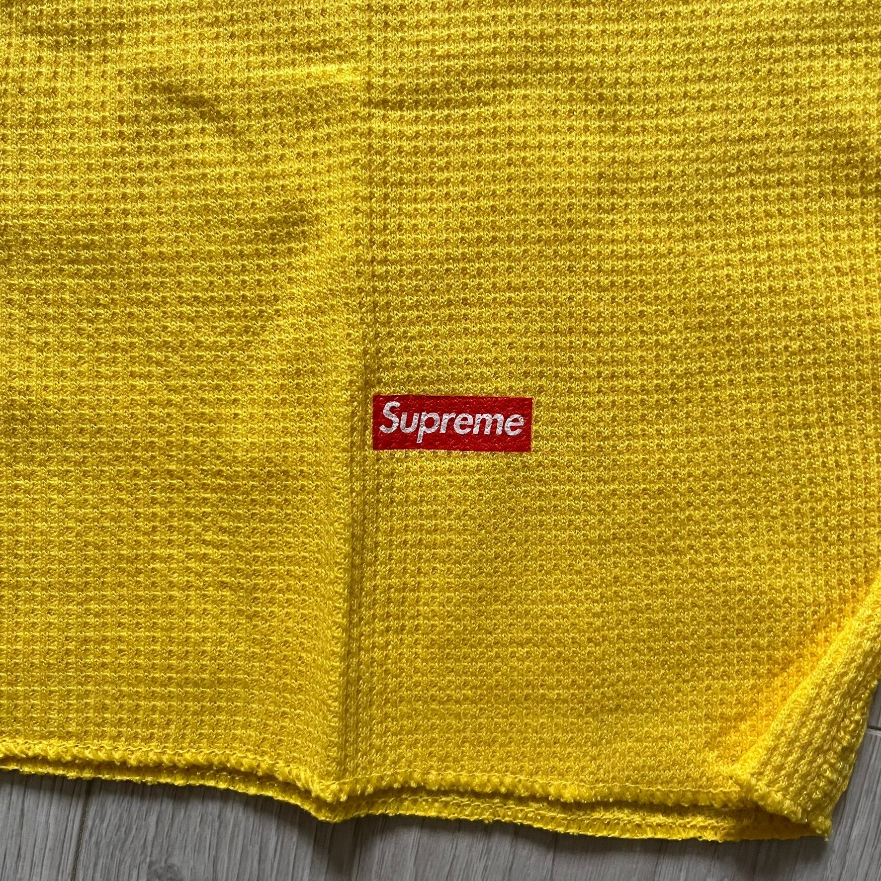 Supreme Hanes Bones Thermal Crew from FW25, crafted from 100% cotton in yellow with black bone graphics. Features a ribcage-inspired skeleton print on the front, matching arm bone designs on the sleeves, and a small Supreme logo near the hem. Released on October 23, 2025.