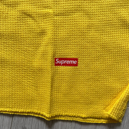 Supreme Hanes Bones Thermal Crew from FW25, crafted from 100% cotton in yellow with black bone graphics. Features a ribcage-inspired skeleton print on the front, matching arm bone designs on the sleeves, and a small Supreme logo near the hem. Released on October 23, 2025.